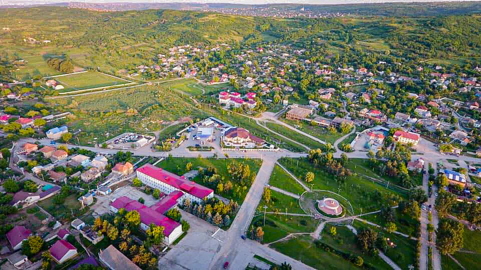Vedere aeriană asupra localității Cojușna și a colinelor împădurite din jur.